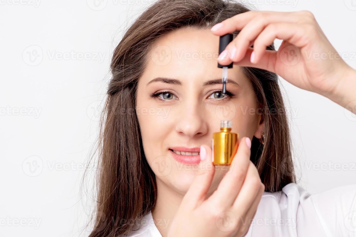 manicurist holds nail varnish bottle photo