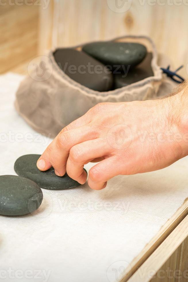 masajista toma negro masaje piedras foto