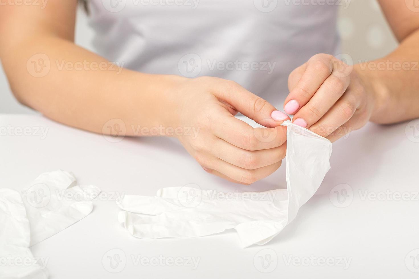 Doctor puts on white gloves photo