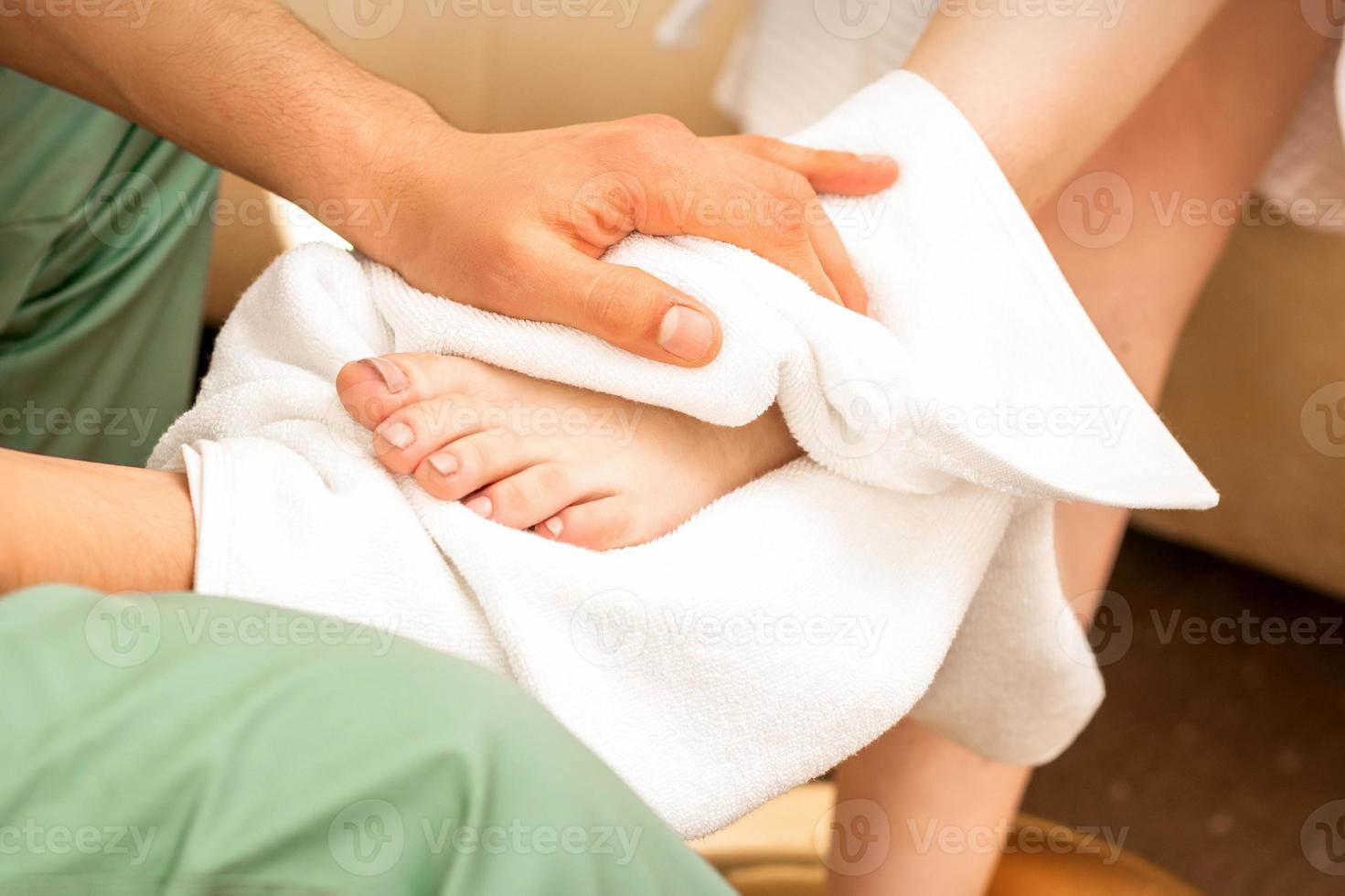 Masseur wiping the woman's legs photo