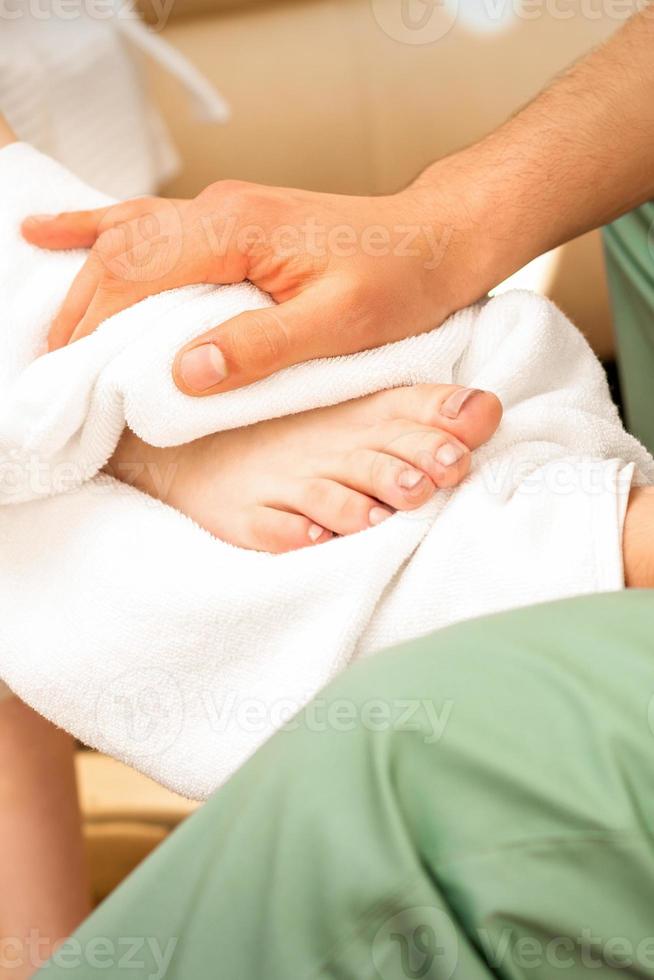 Masseur wiping the woman's legs photo