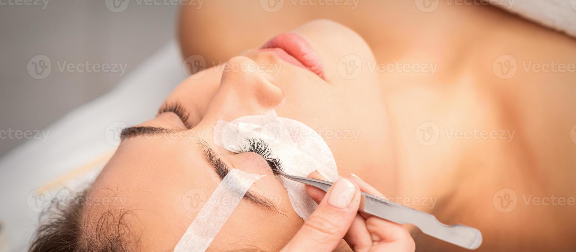 Woman having eyelash extension procedure photo