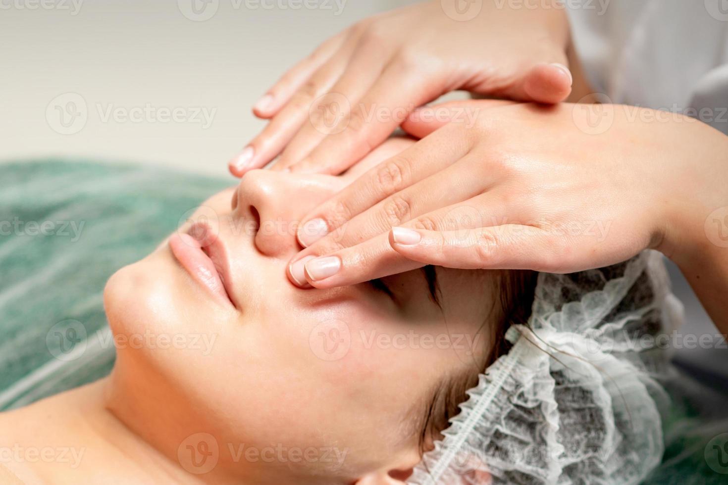 Young woman getting facial massage photo