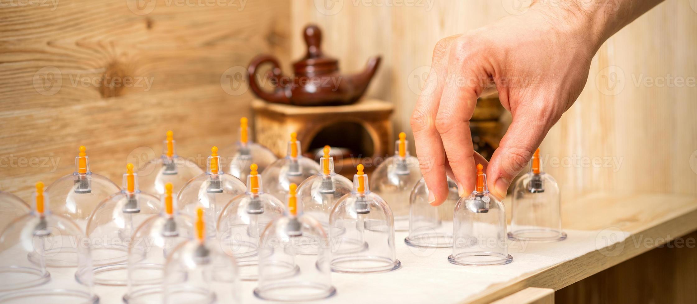 Therapist takes vacuum glass jars photo