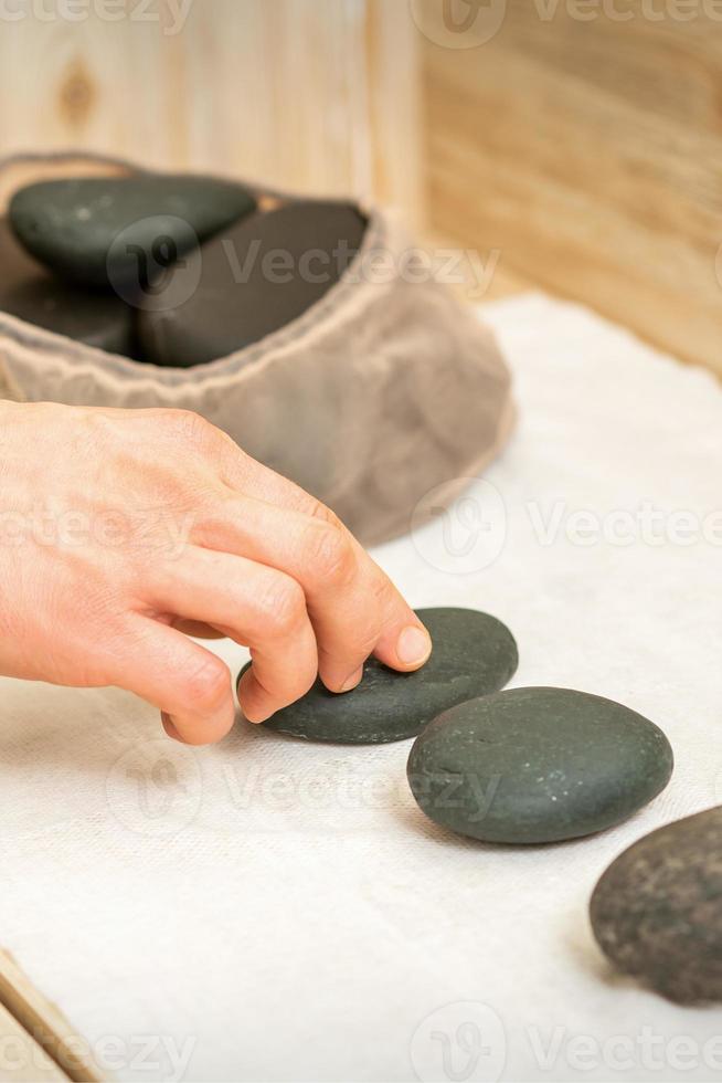 masajista toma negro masaje piedras foto