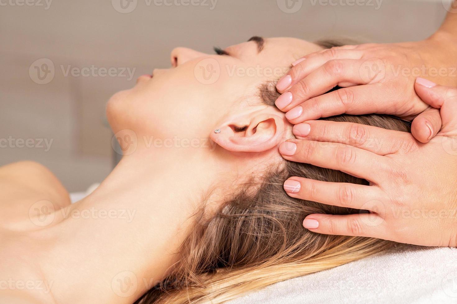 Young woman receiving head massage photo