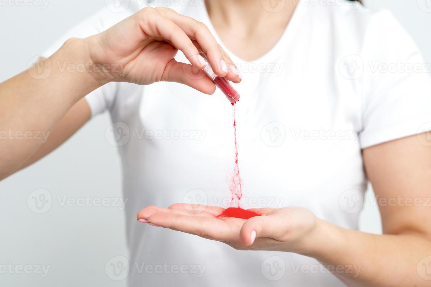 Manicurist pours red pigment nail powder photo