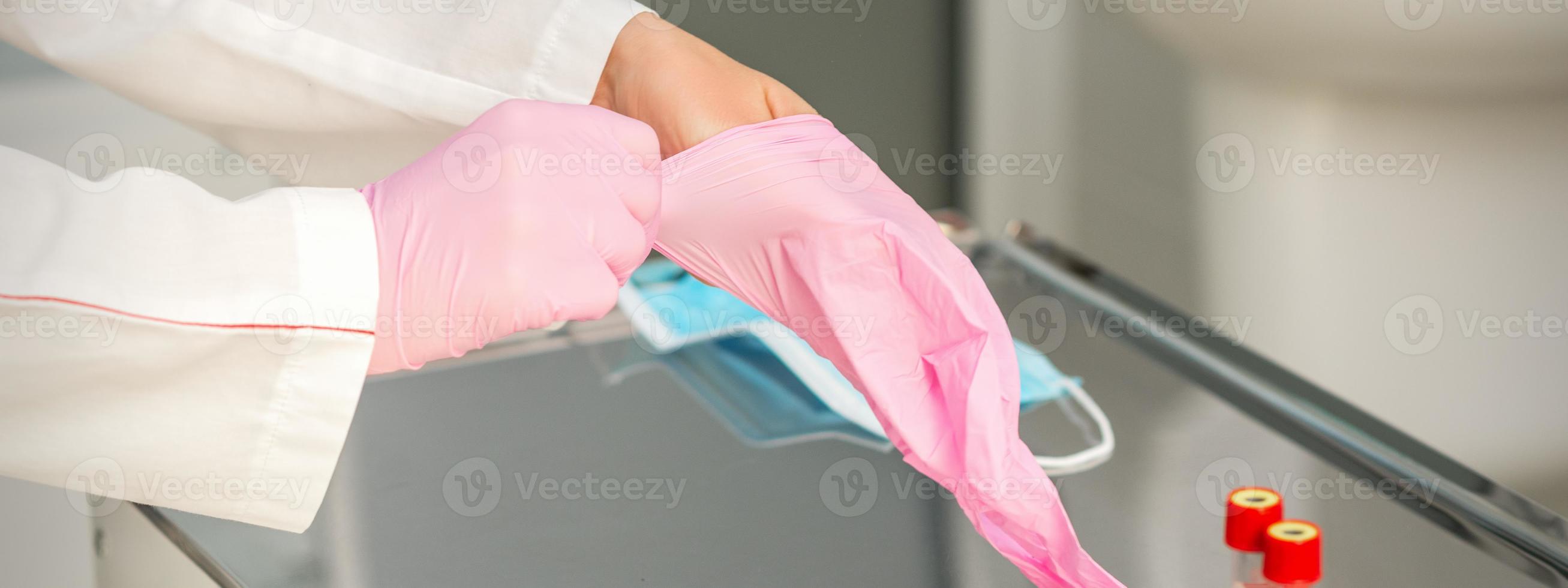 Doctor wearing rubber protective gloves photo