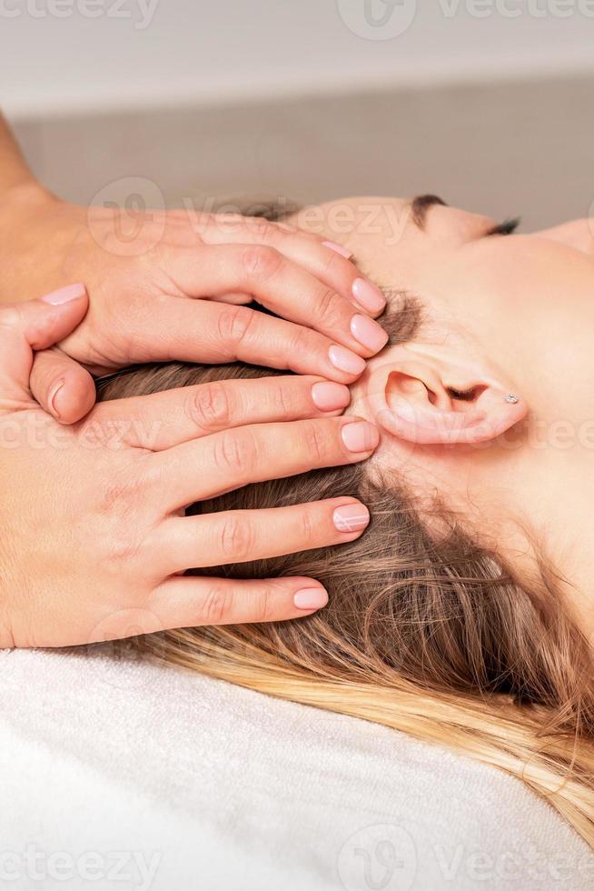 Young woman receiving head massage photo