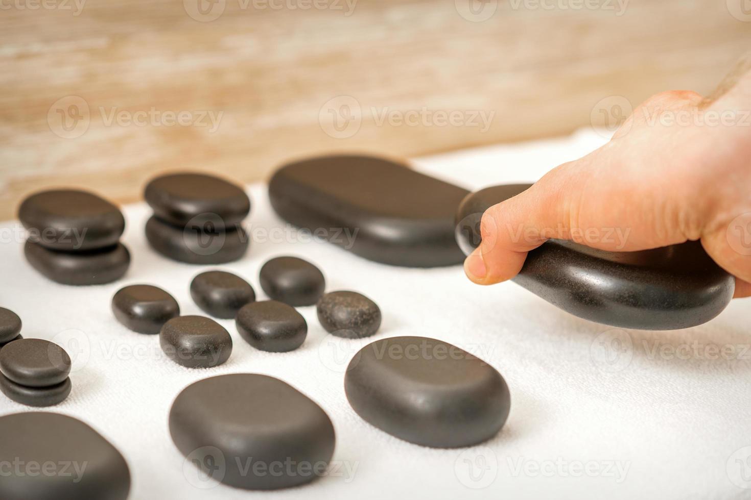 Masseur lays out massage stones photo