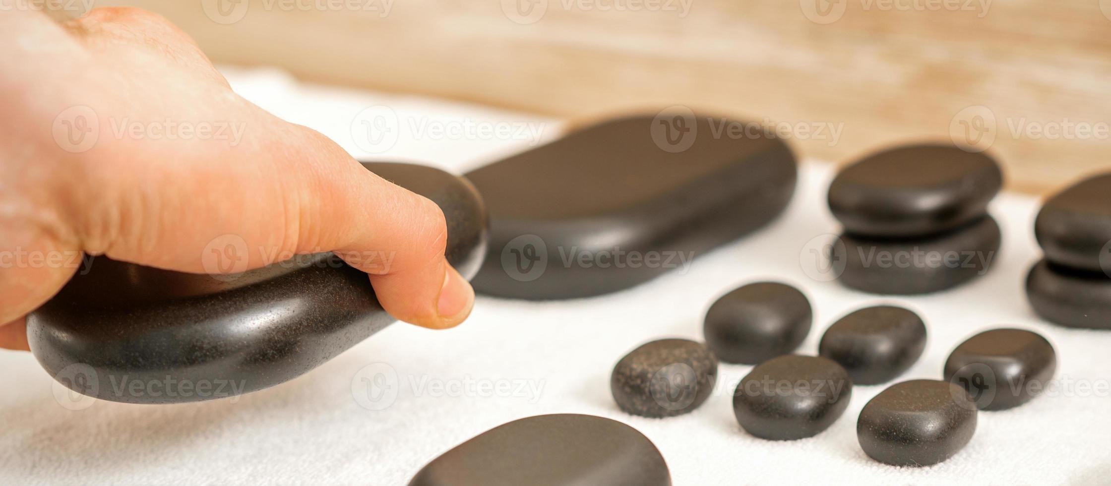 Masseur lays out massage stones photo