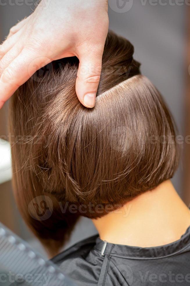 Hairdresser checks short brown hairstyle photo