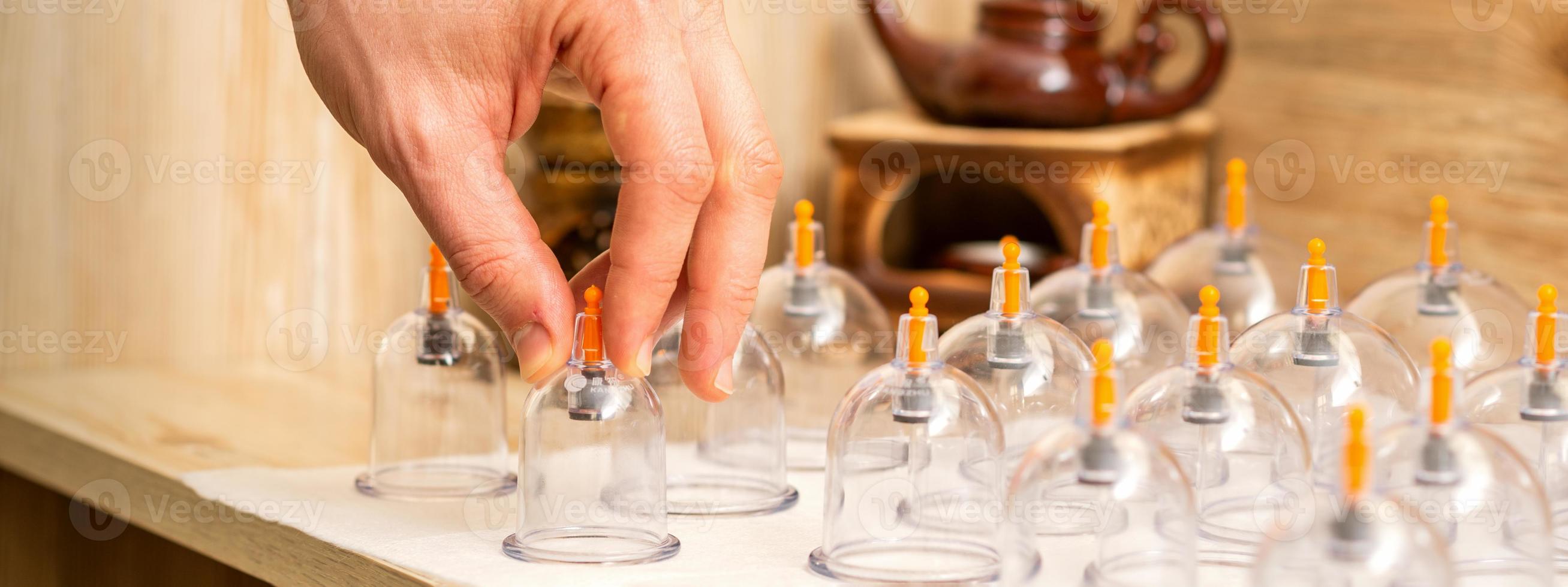 Therapist takes vacuum glass jars photo