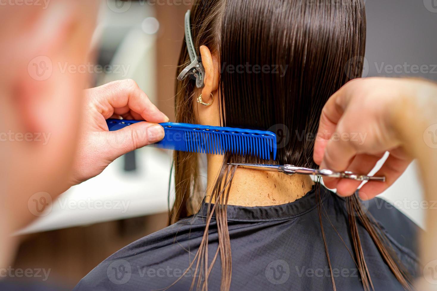Hairdresser cuts hair of woman photo