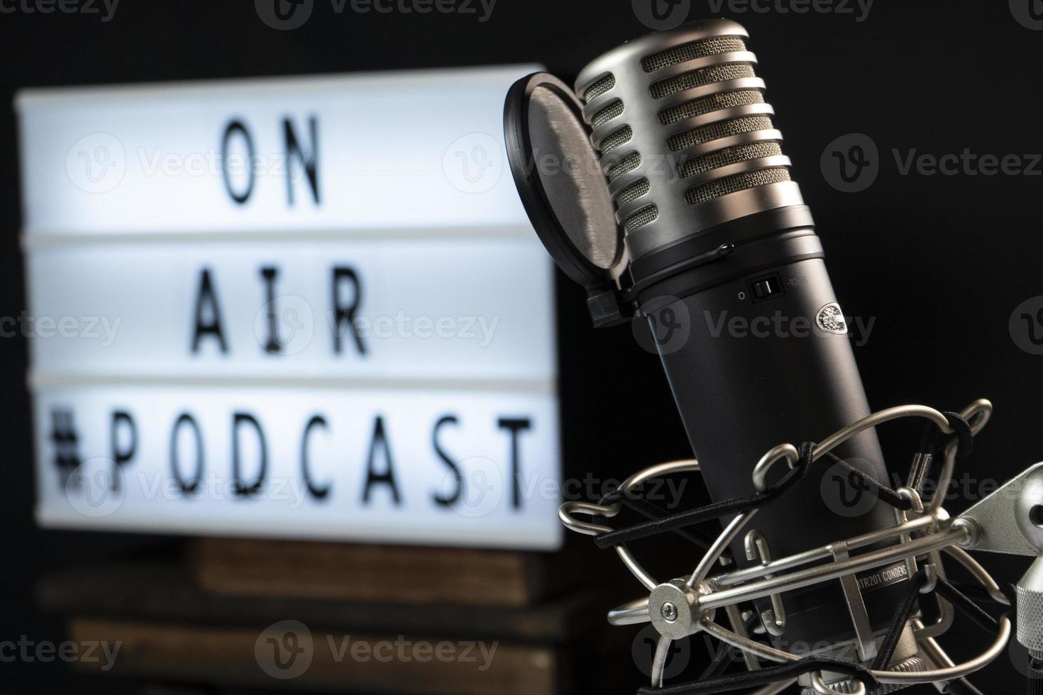 Podcast setting with microphone and a light sign reading on air photo