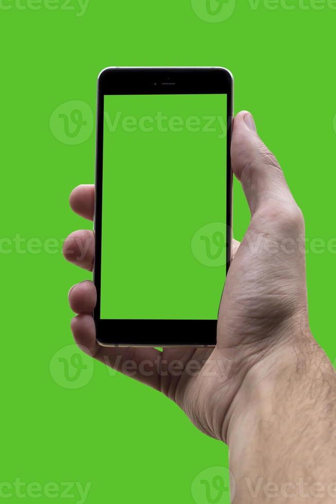 Male hand holding black cellphone with green croma screen at isolated Green background. photo