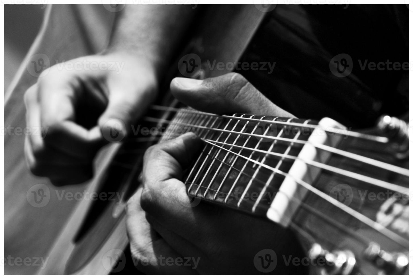 cerca arriba de manos jugando un acorde en un guitarra, negro y blanco foto