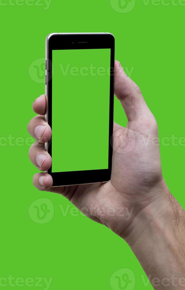 Male hand holding black cellphone with green croma screen at isolated Green background. photo