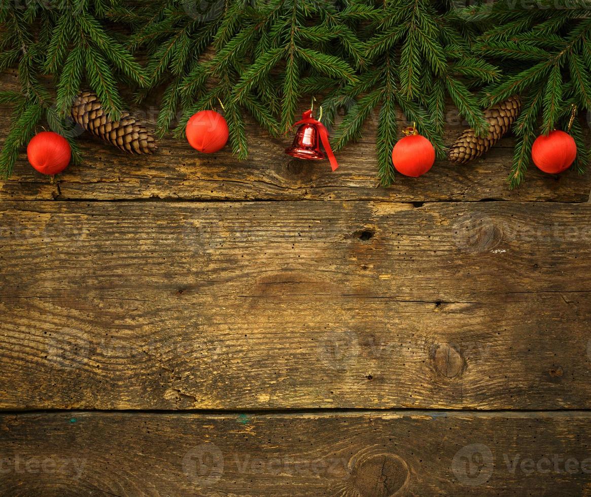 Christmas tree branches with cones and christmas decorations on wooden texture ready for your design photo