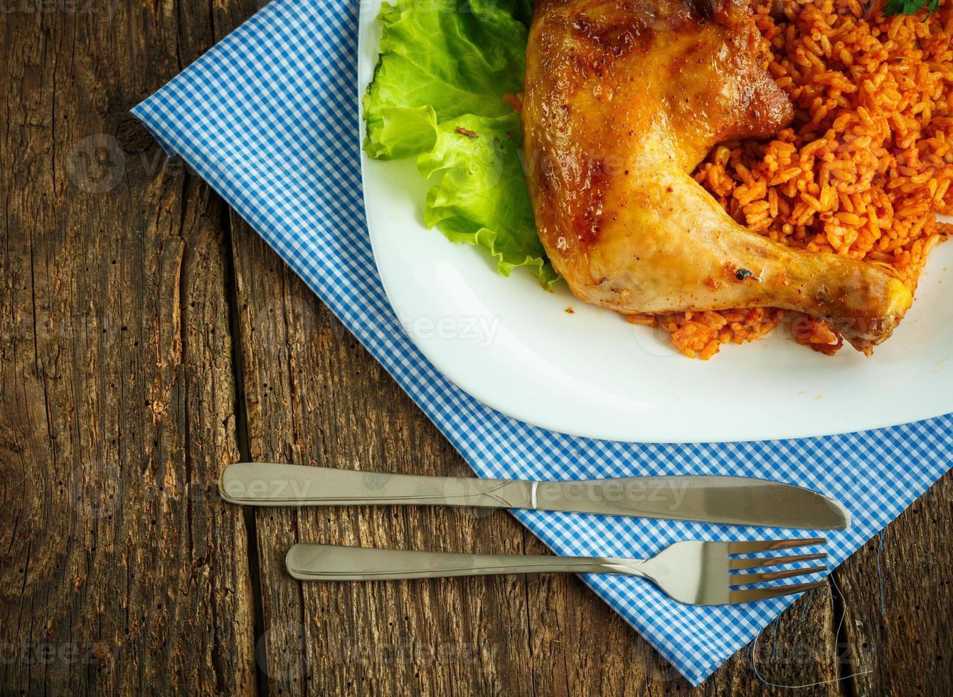 delicioso plato de pollo muslo con arroz y ensalada hojas foto