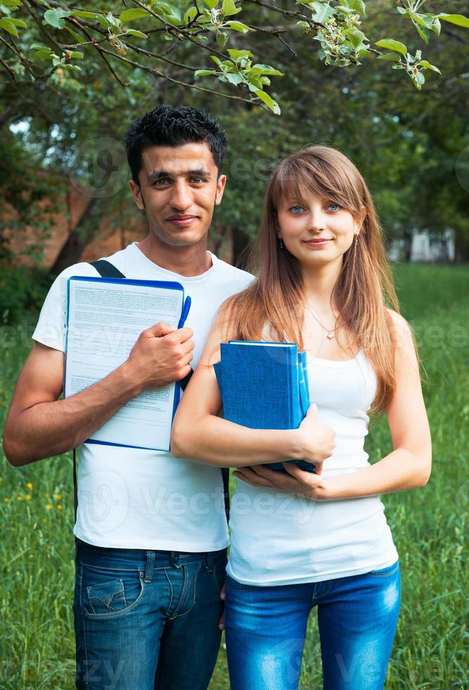 Two students in park with book outdoors photo