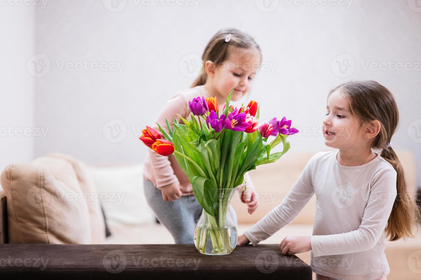 dos hermanas con primavera tulipán ramo. fiesta decoración con flores vistoso tulipanes foto