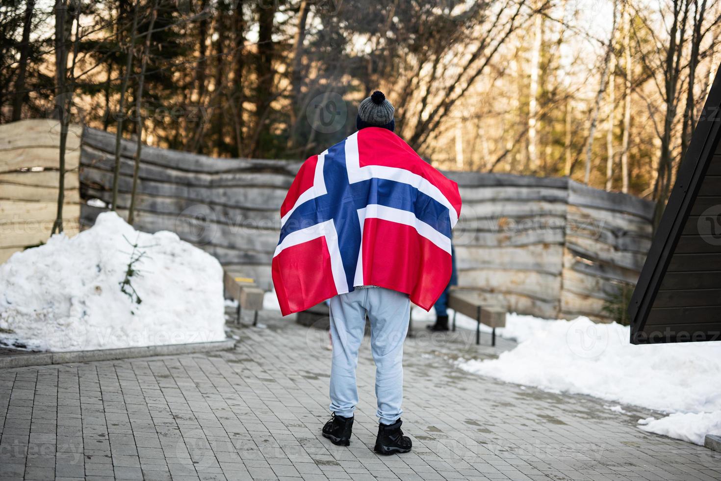 Back of man holding Norway flag. Scandinavian culture, norwegian people. photo