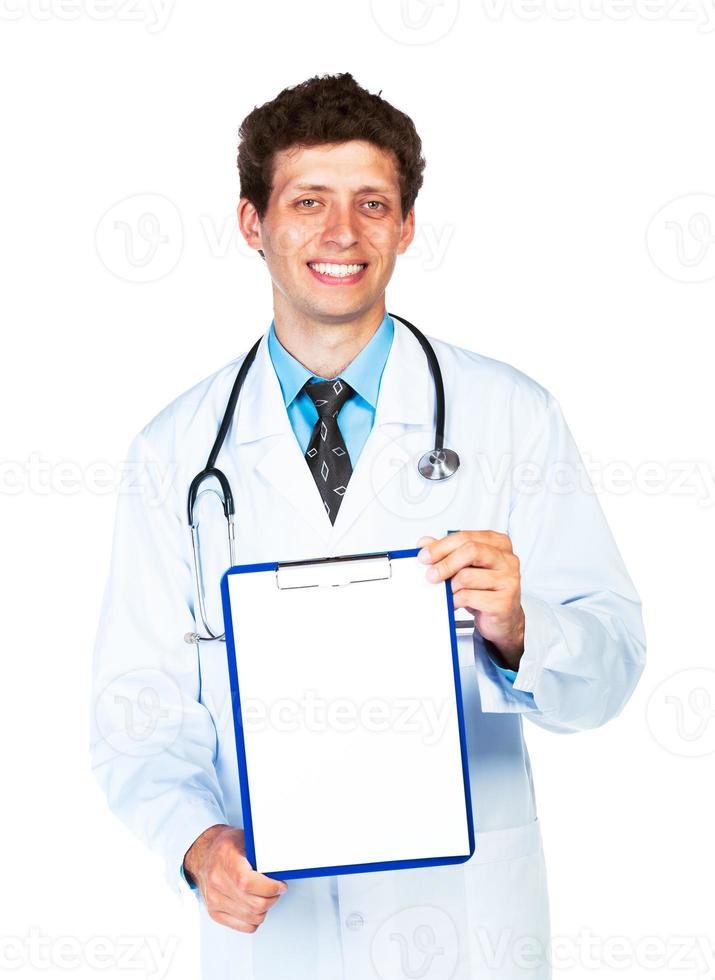 Young male smiling doctor showing clipboard with copy space for text on white photo