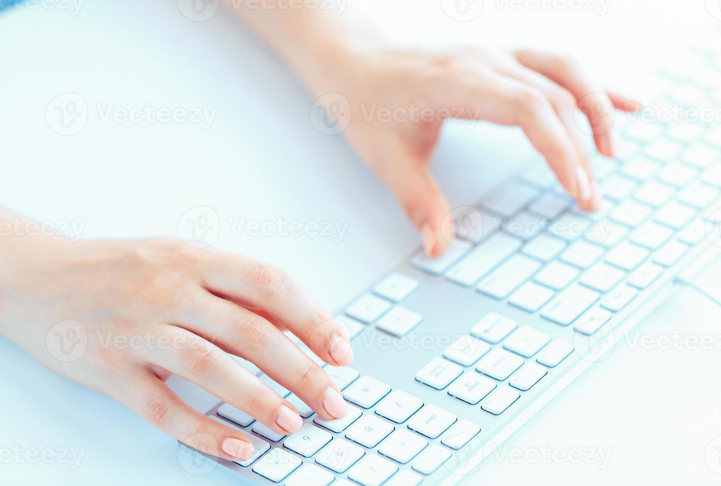 Female hands or woman office worker typing on the keyboard photo