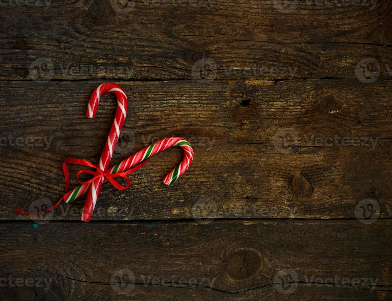 Closeup of two old fashioned candy canes on a rustic wooden background photo