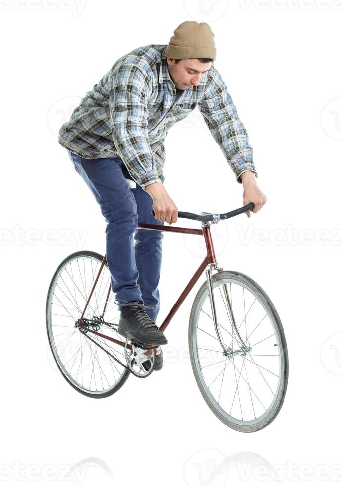 Young man doing tricks on a bicycle on a white photo