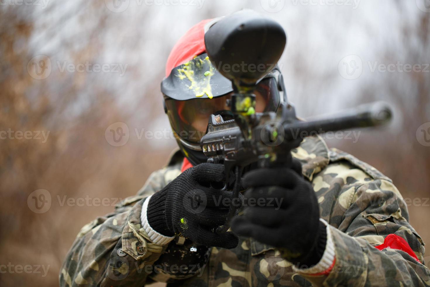 paintball deporte jugador vistiendo protector máscara y puntería pistola foto