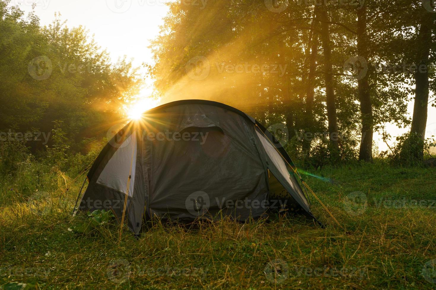 turista carpas en orilla del río a amanecer foto