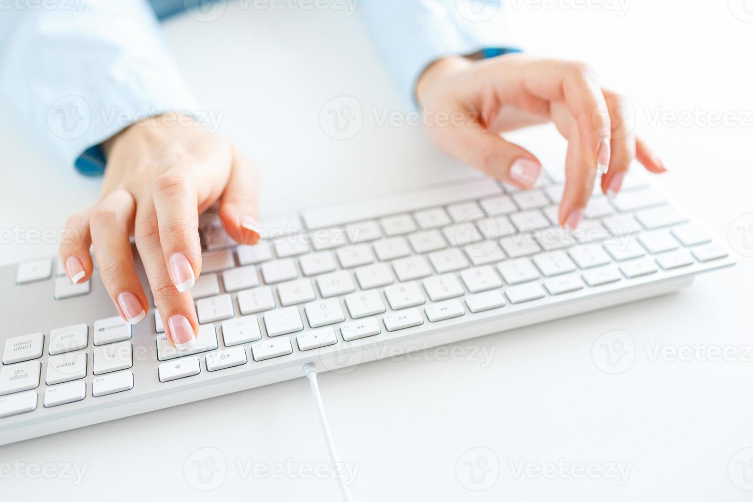 Woman office worker typing on the keyboard photo