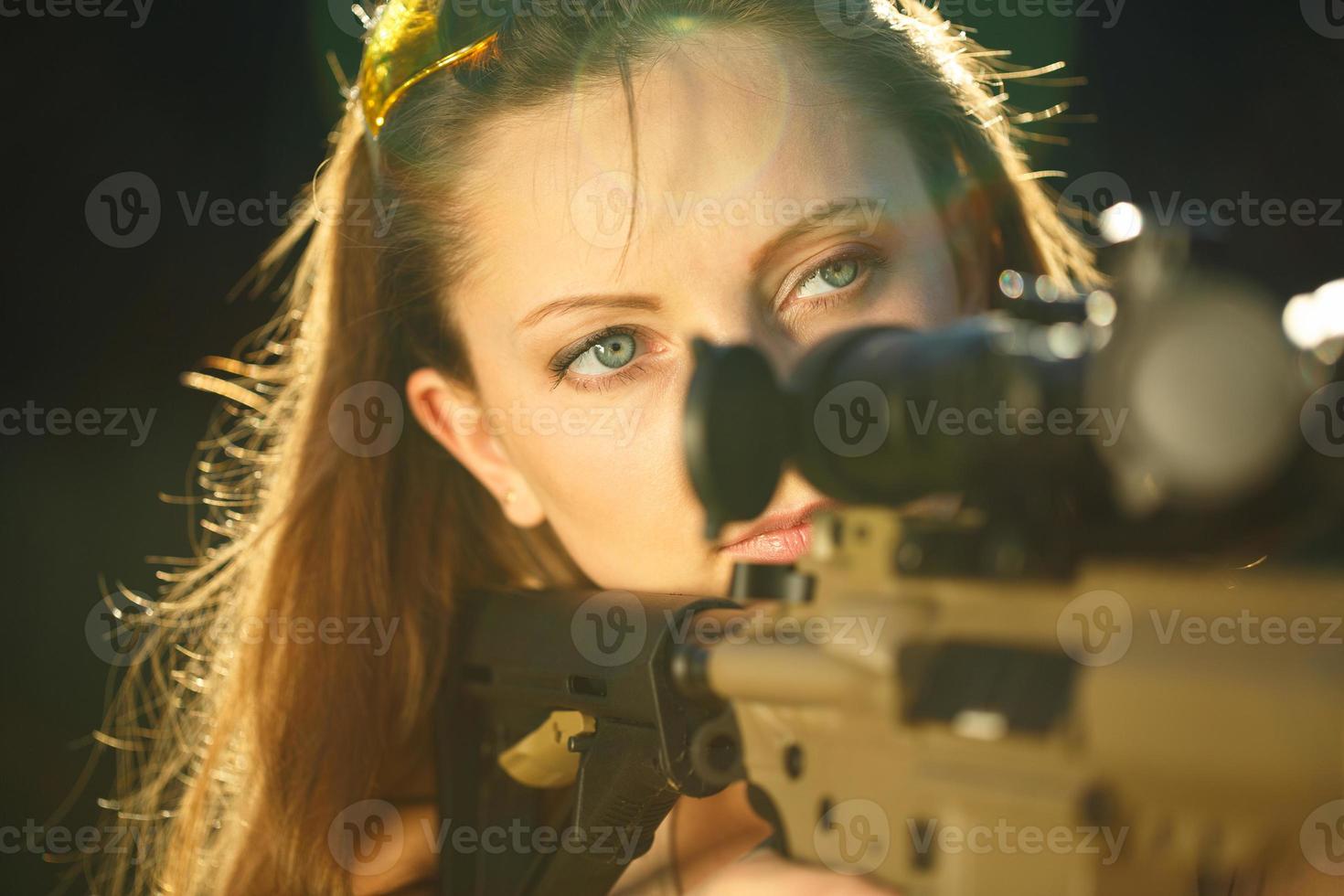 Girl with a gun for trap shooting aiming at a target photo