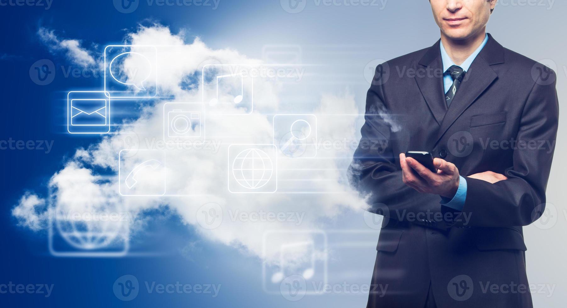 Businessman with touch screen phone and the cloud with icons photo