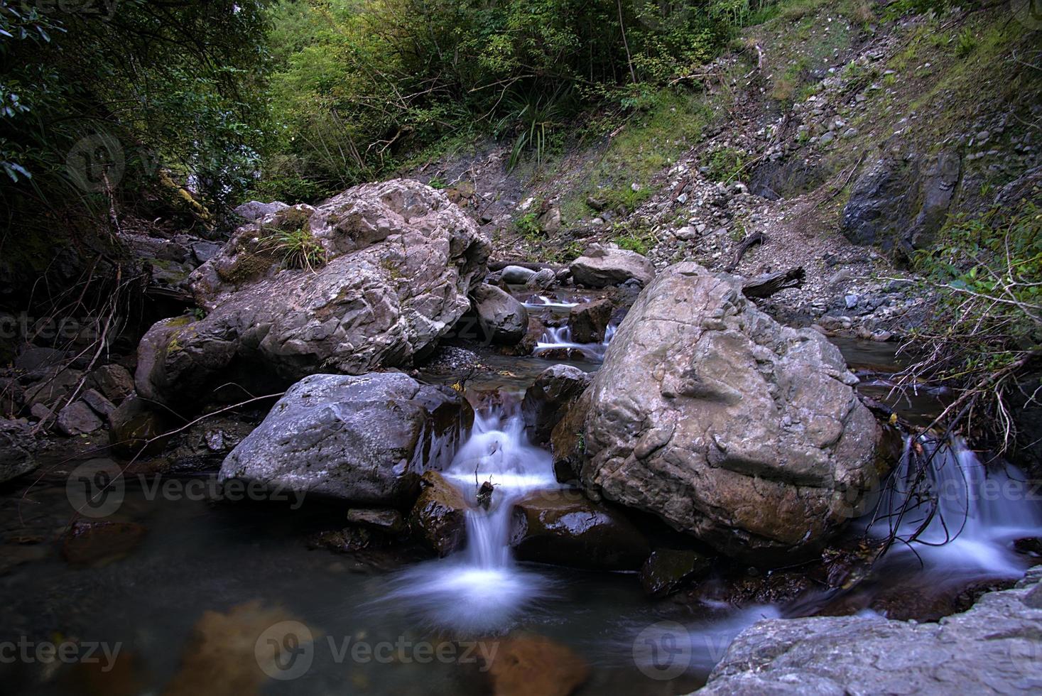 small waterfall going trough the rocks photo