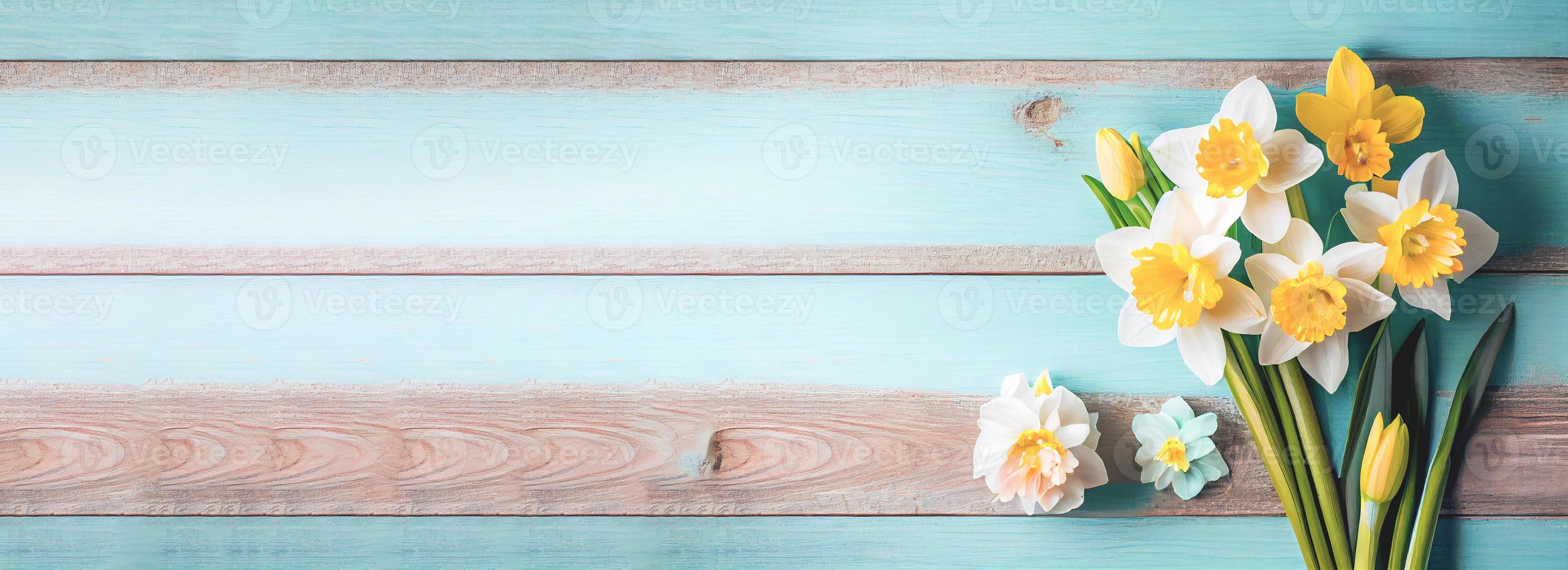 Spring easter background with top view of daffodils bouquet on light blue wooden table with copy space photo