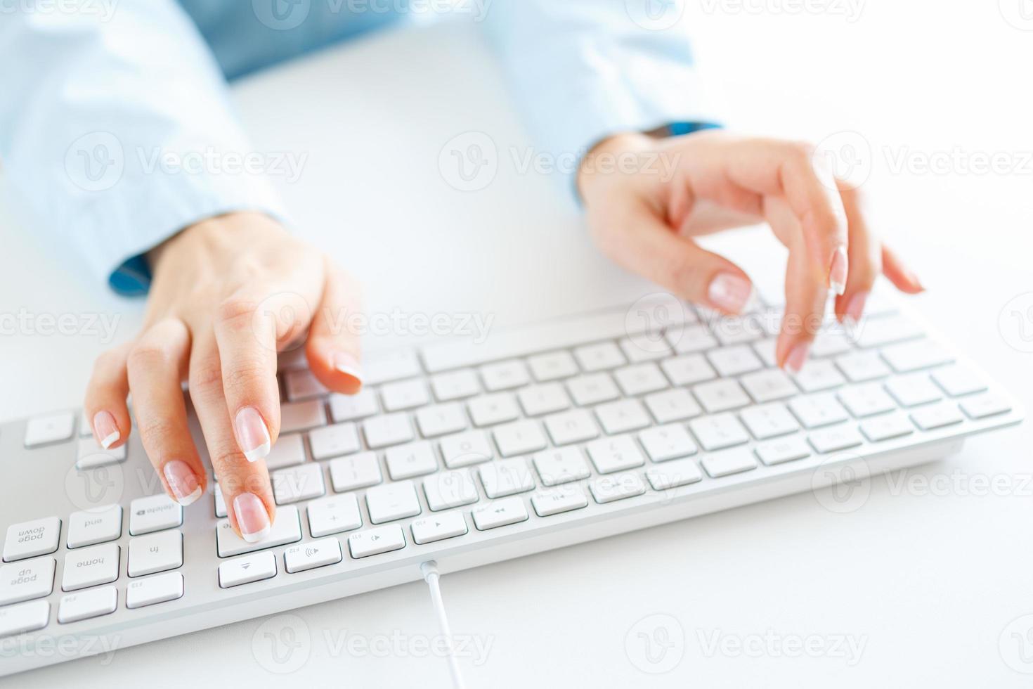 Woman office worker typing on the keyboard photo