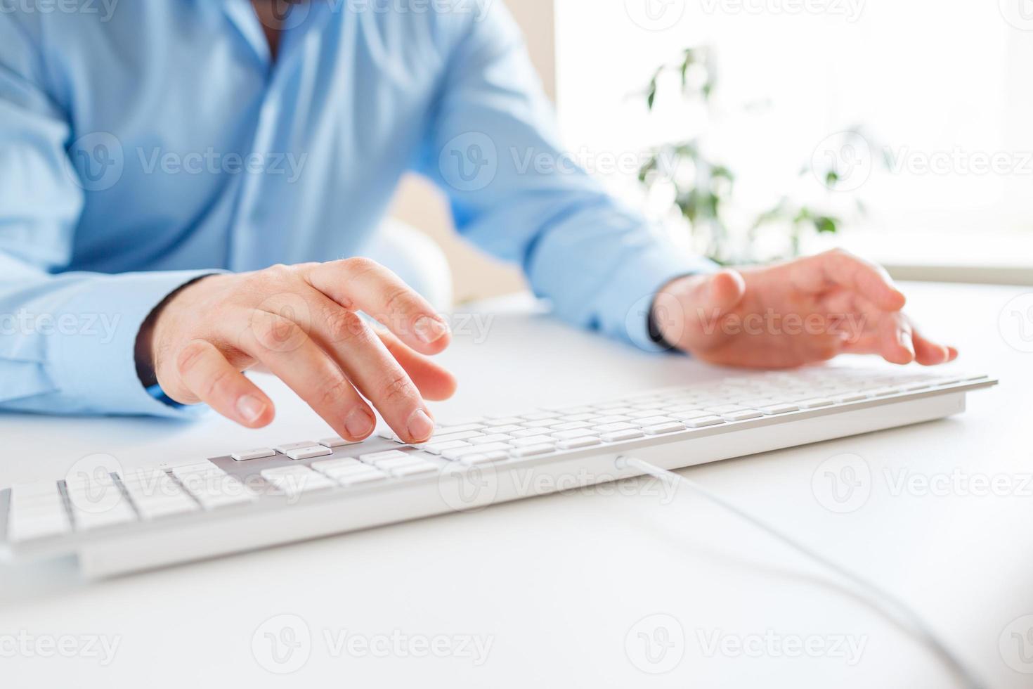 Man office worker typing on the keyboard photo