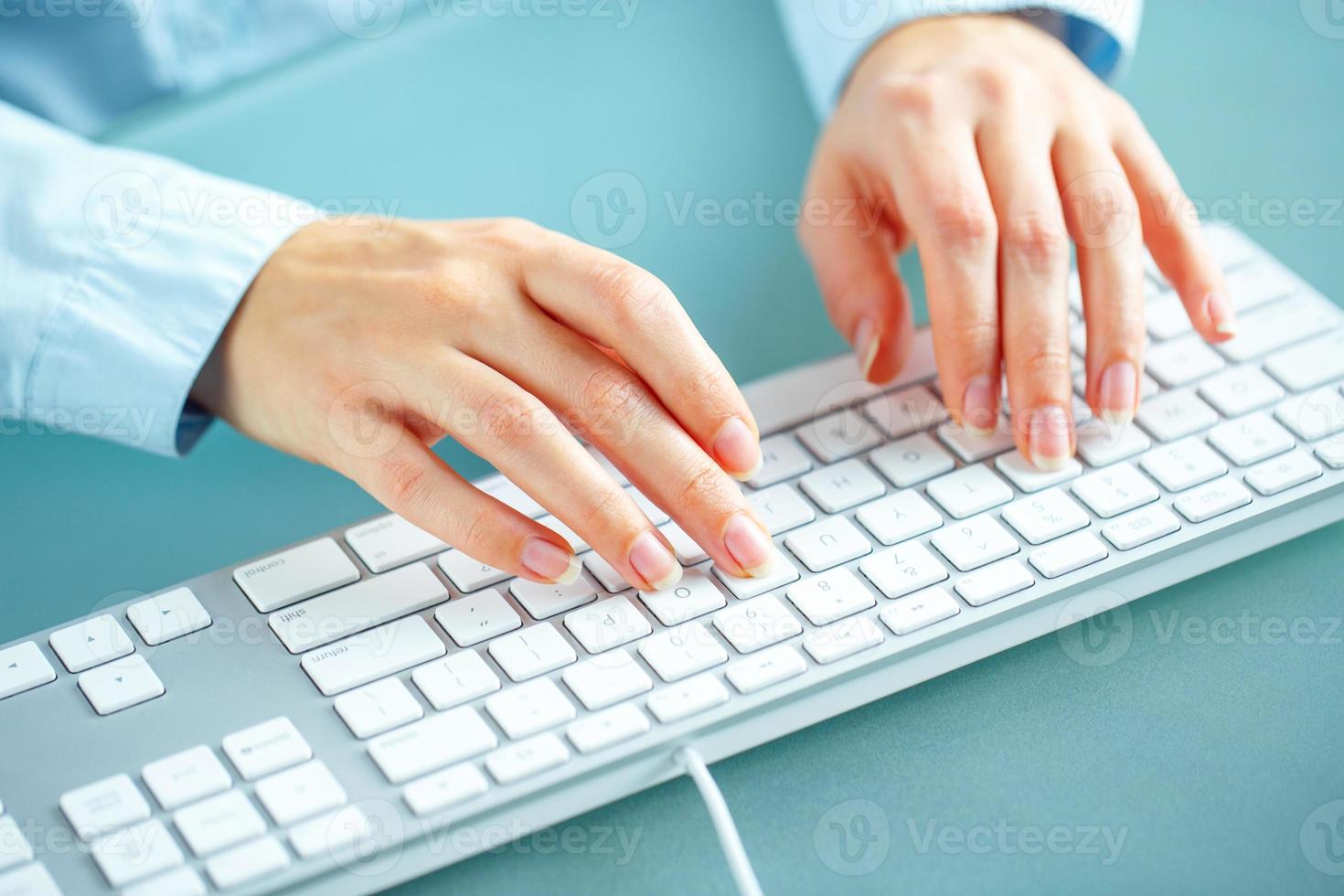 Woman office worker typing on the keyboard photo