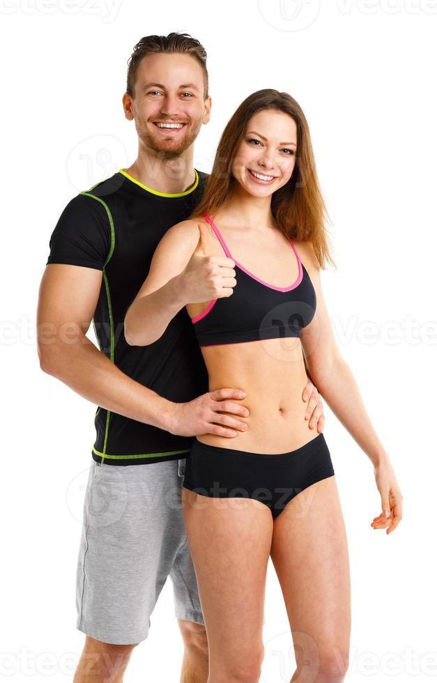 Athletic man and woman after fitness exercise with thumbs up on the white photo