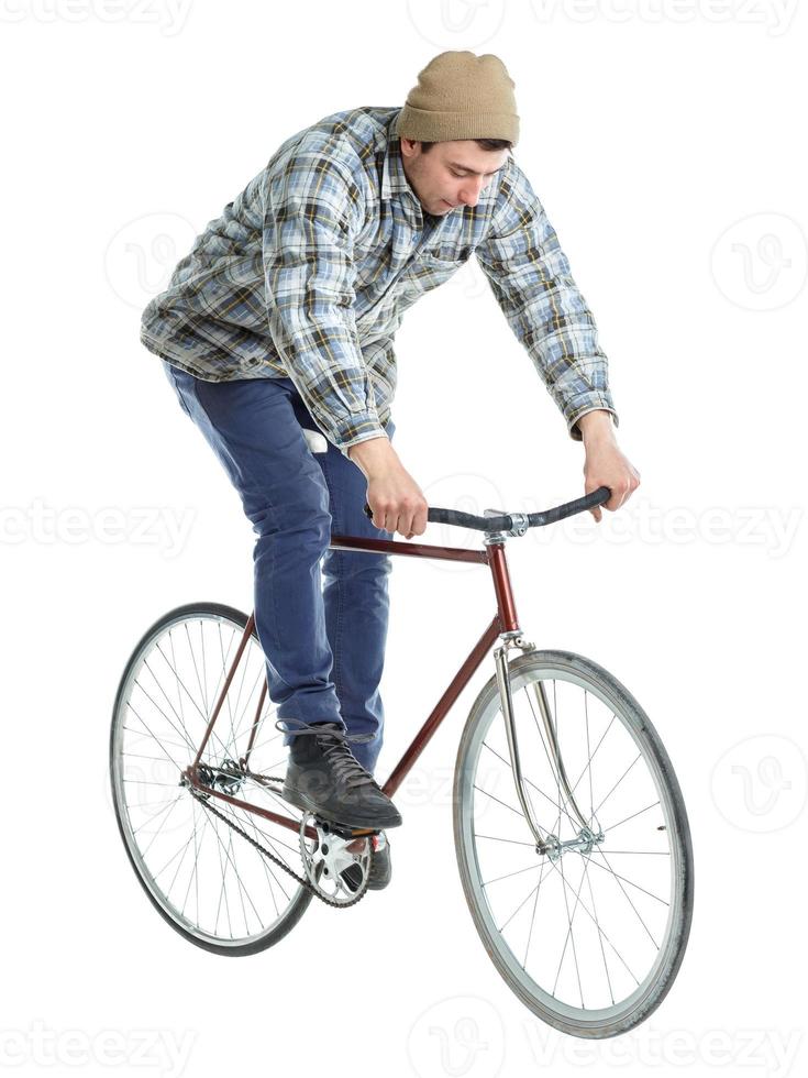 Young man doing tricks on a bicycle on a white photo