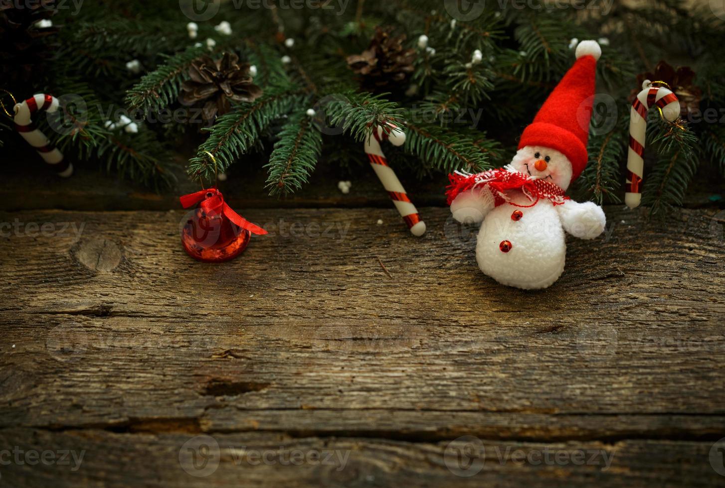 Christmas tree branches with christmas decorations and snowman on wooden texture photo