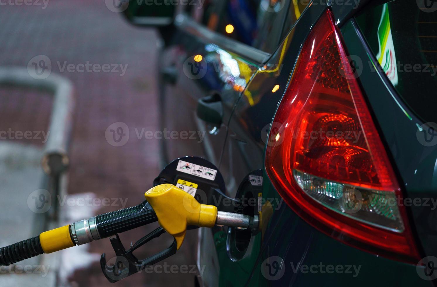 Car refueling on a petrol station at night photo