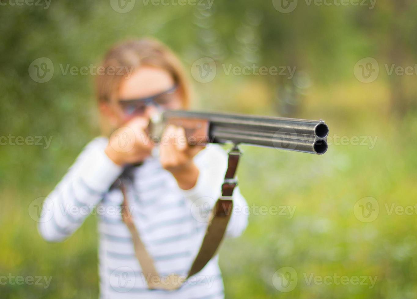 un joven niña con un pistola para trampa disparo foto