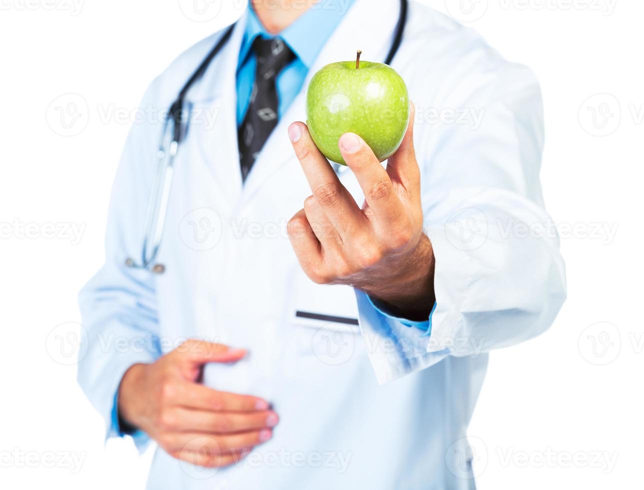 Doctor's hand holding a fresh green apple close-up photo
