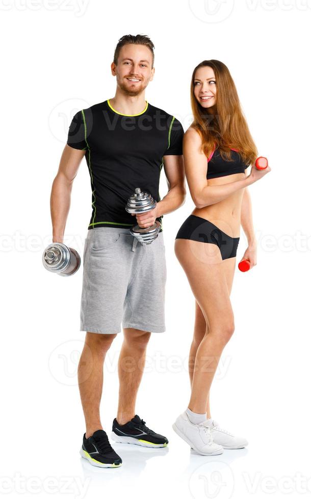 Sport couple - man and woman with dumbbells on the white photo
