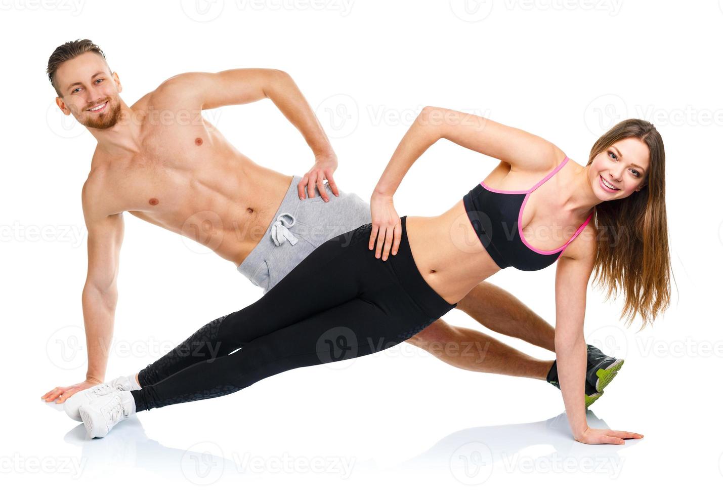 Attractive sport couple - man and woman doing fitness exercises on the white photo