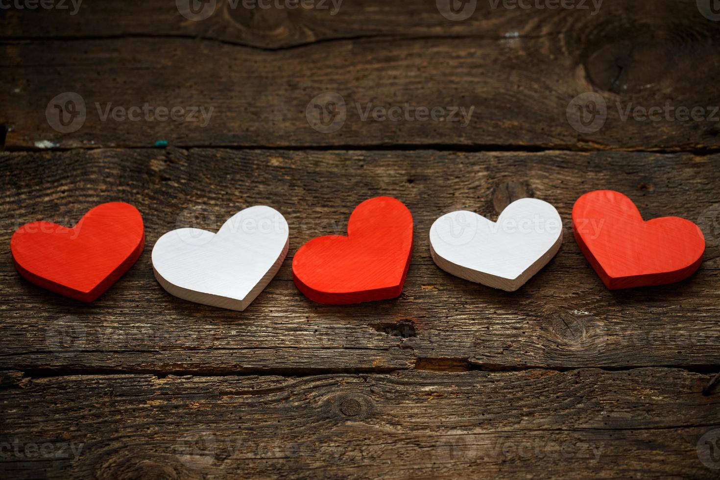 Red and white hearts on old wooden background photo